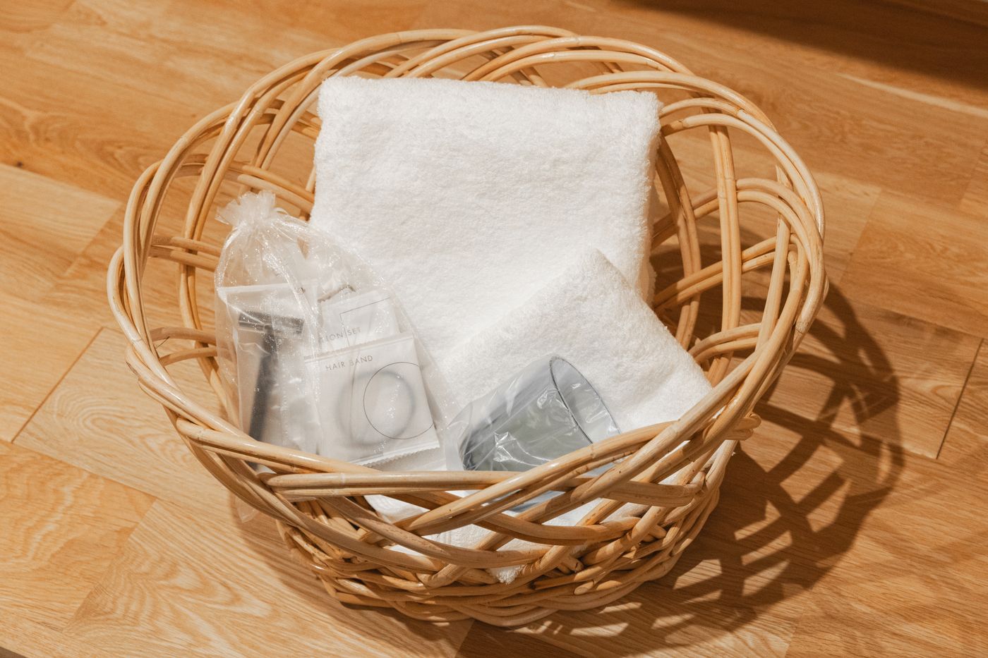 A woven basket with towels and amenity kits