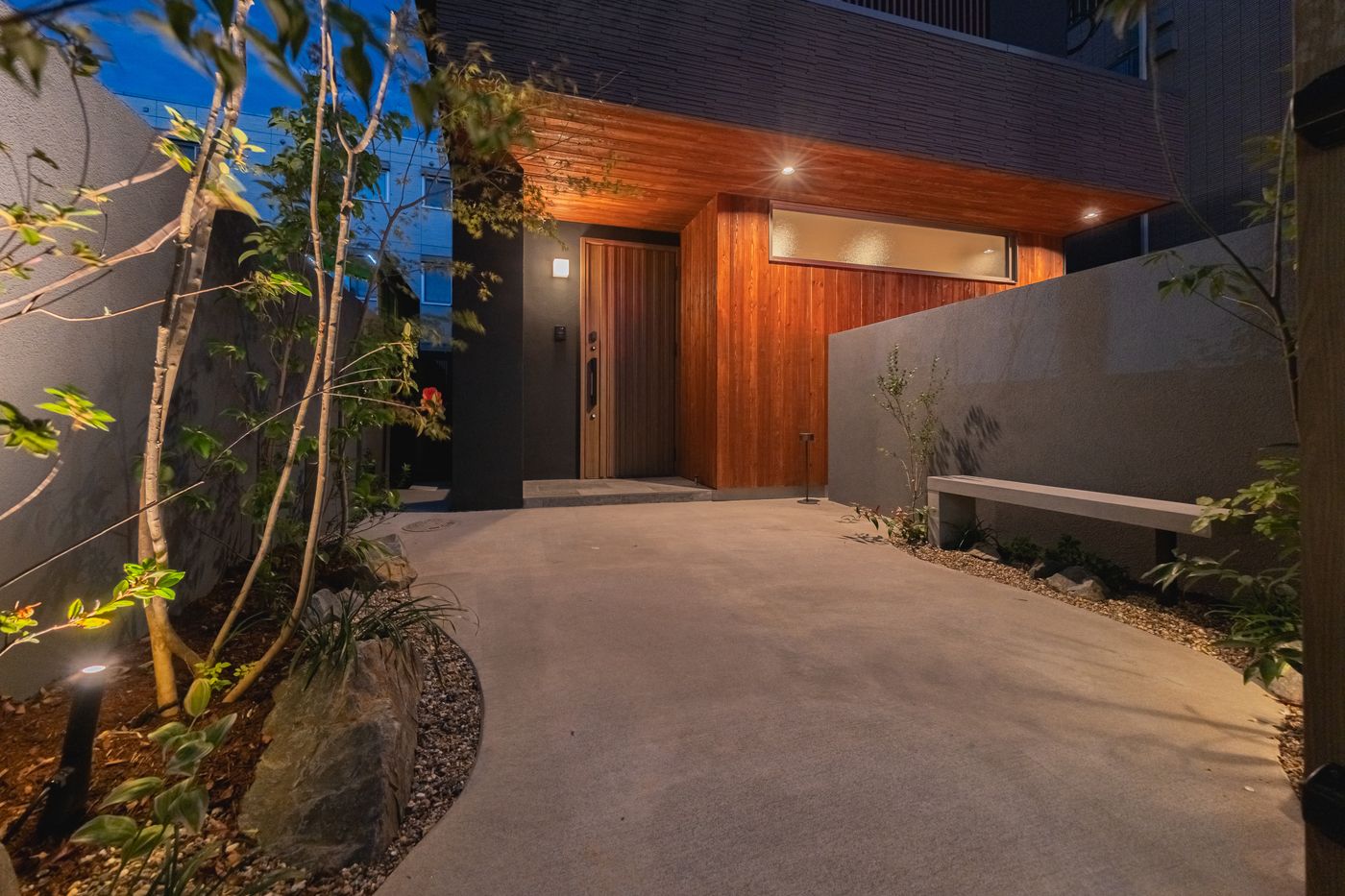 The entrance path at dusk, lit from the doorway