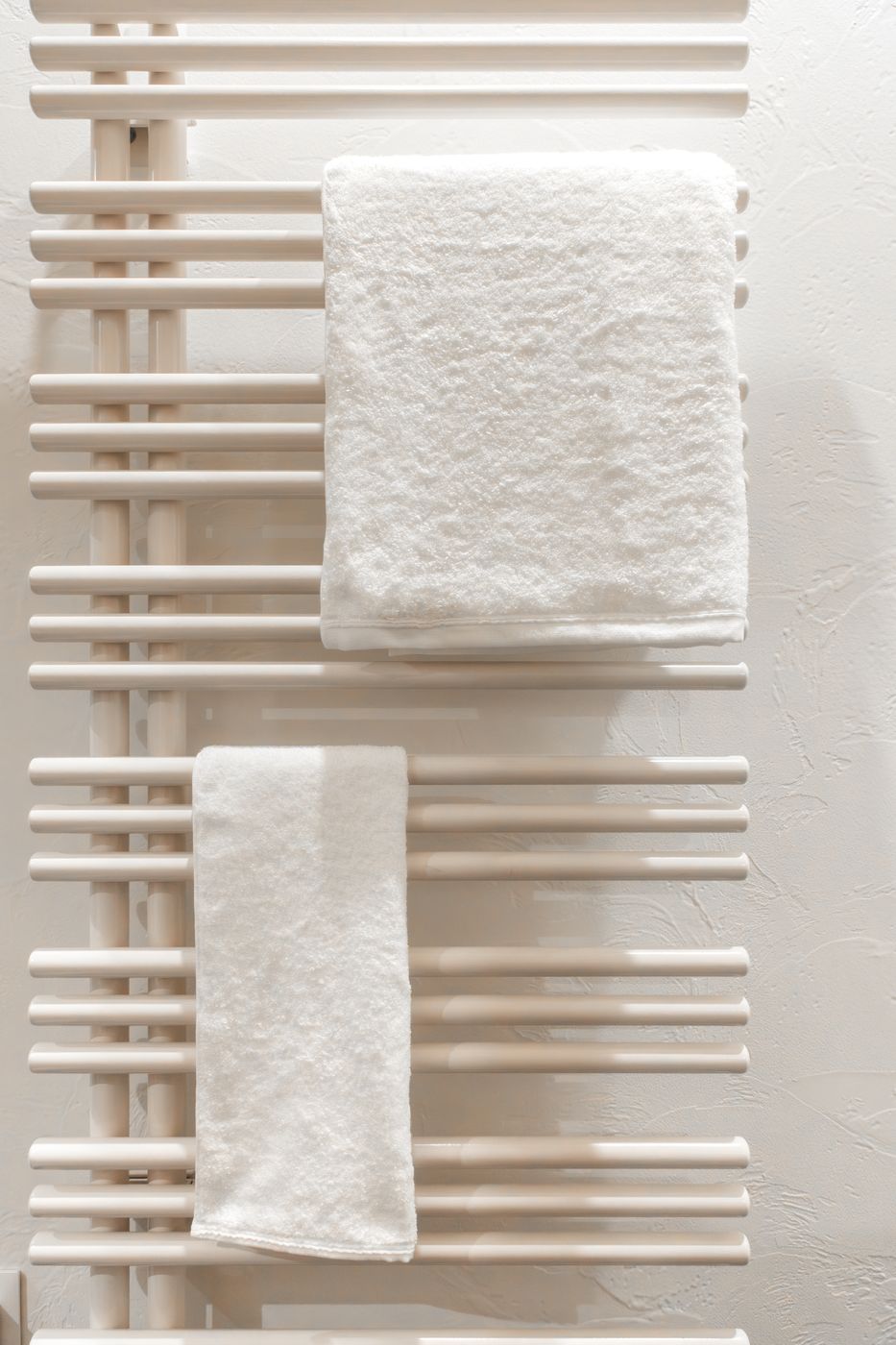 A heated towel rail with folded white towels