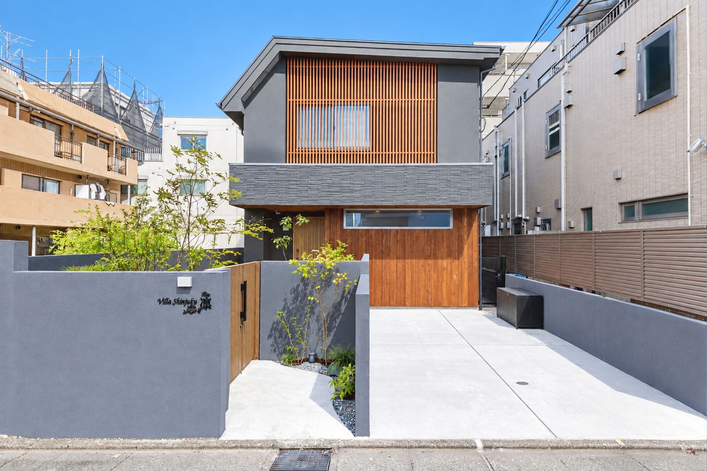The front of Rin by day, with a dark wooden facade and a young tree