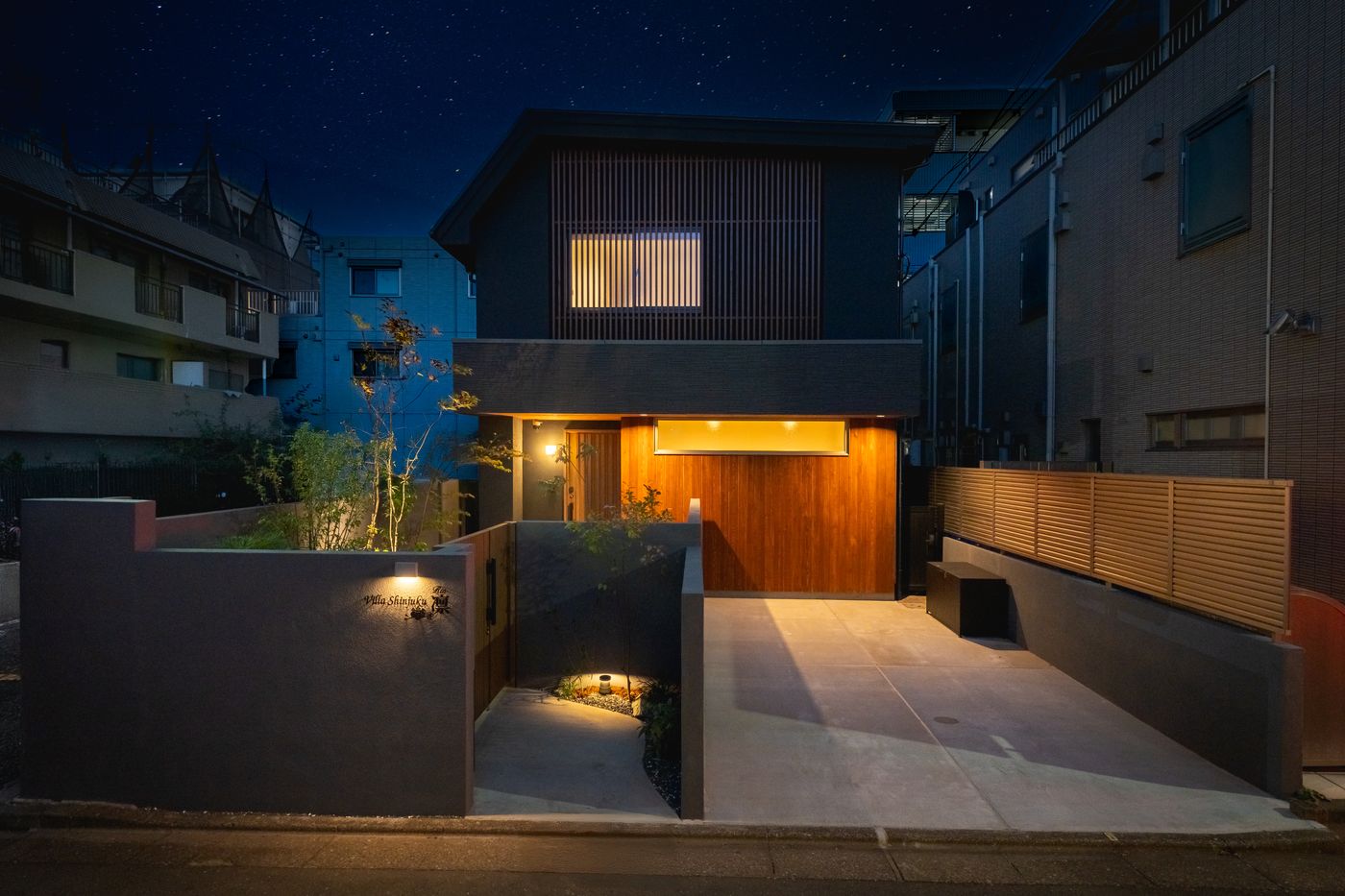 The front of Rin at night, a renovated house in Shin-Okubo with warm light at the entrance