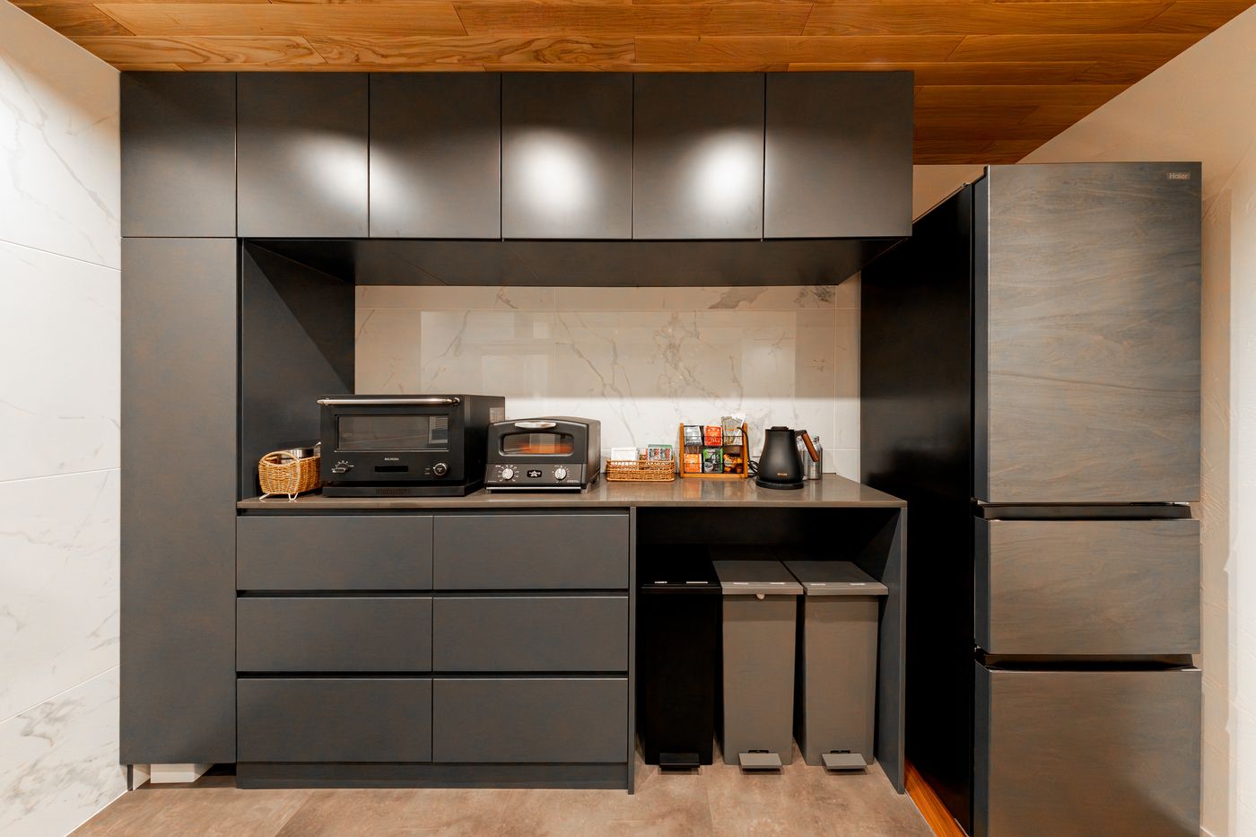 The black kitchen cabinets with oven, kettle and refrigerator
