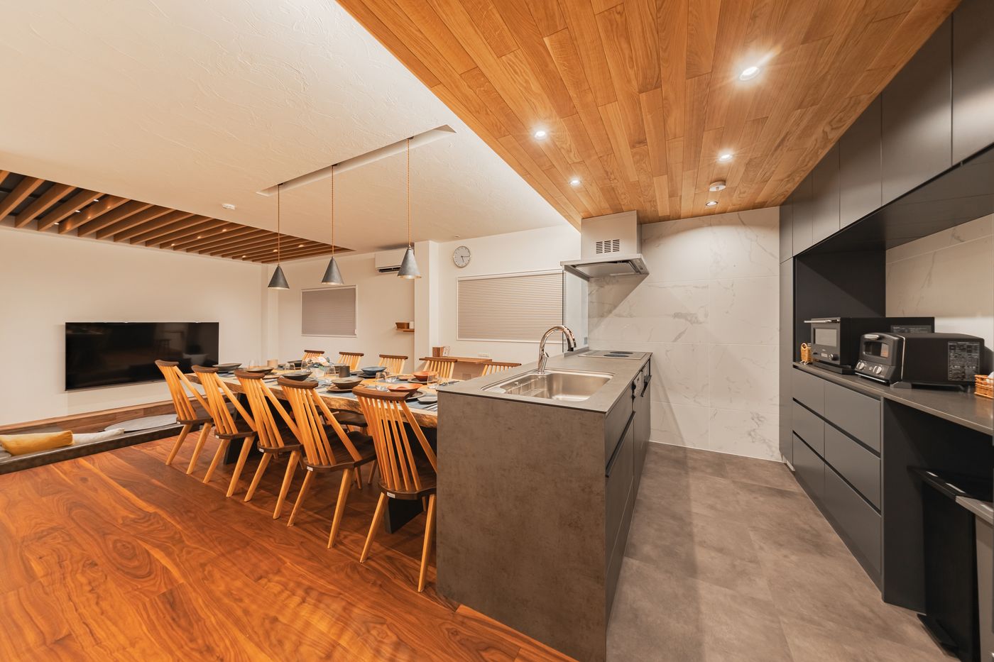 The kitchen island with a steel sink, seen across the dining table