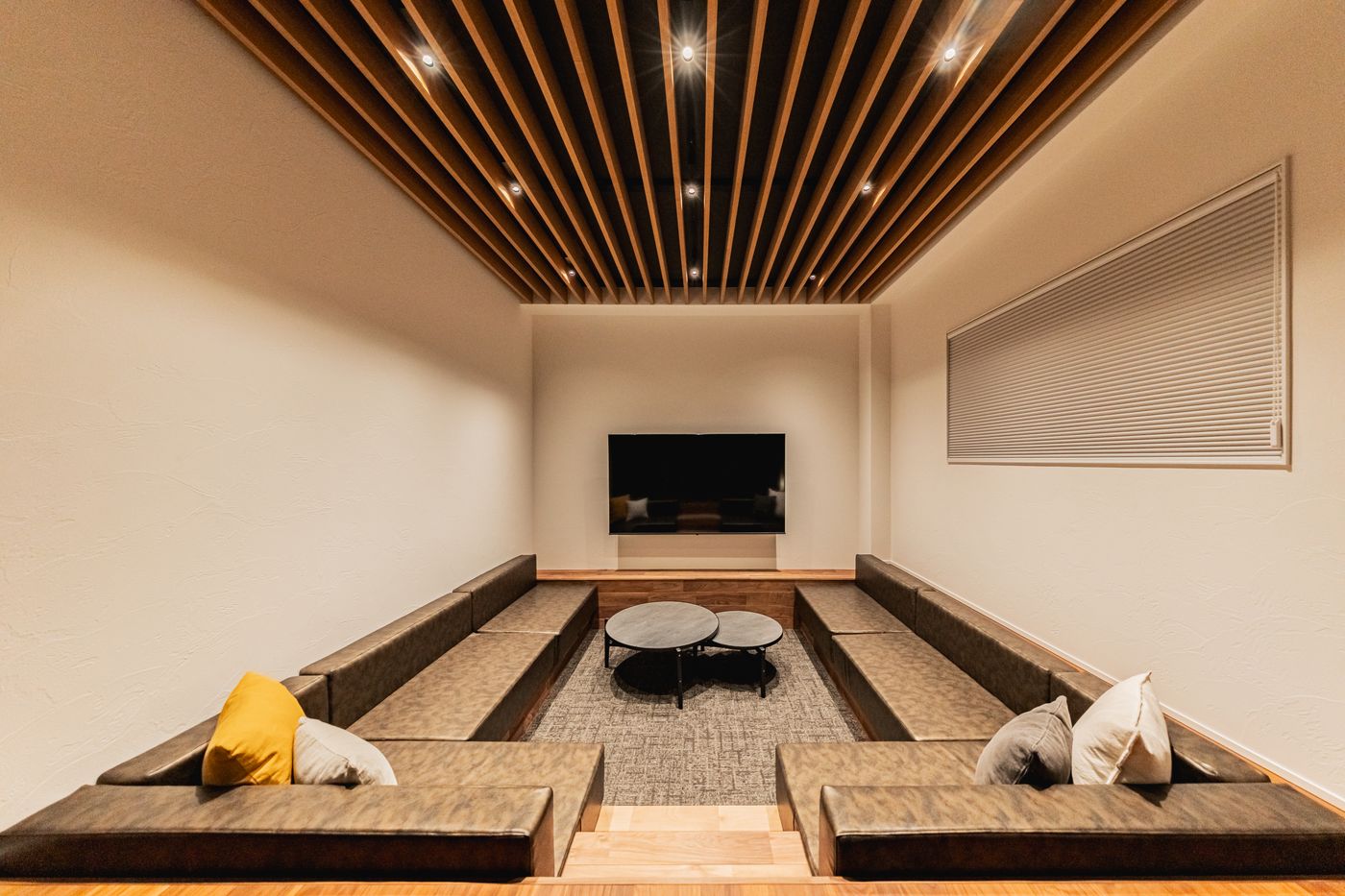 The sunken living room with grey cushions and a low table